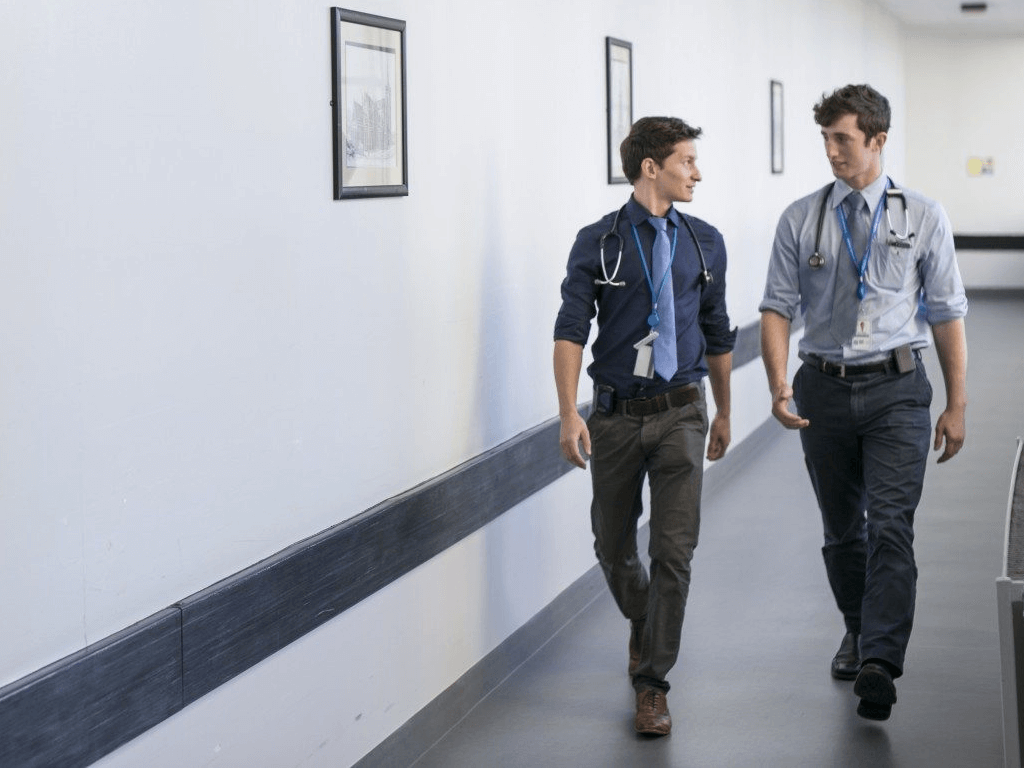 Two male doctors walking through a hospital corridor